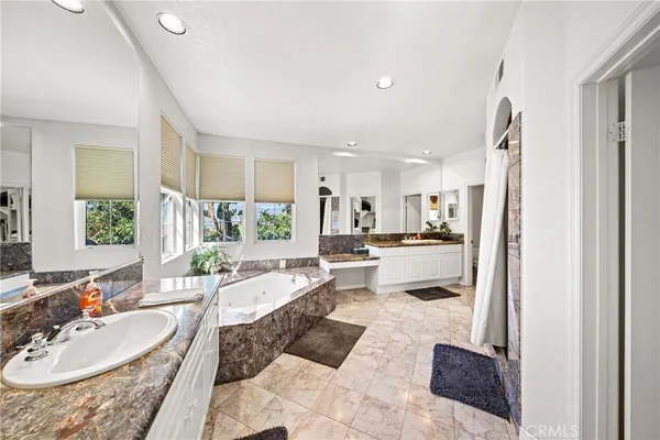 a large living room with stainless steel appliances kitchen island granite countertop furniture and a rug