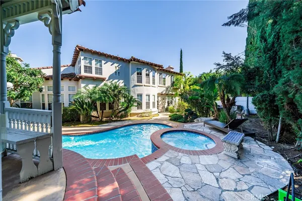 a view of swimming pool with lawn chairs potted plants