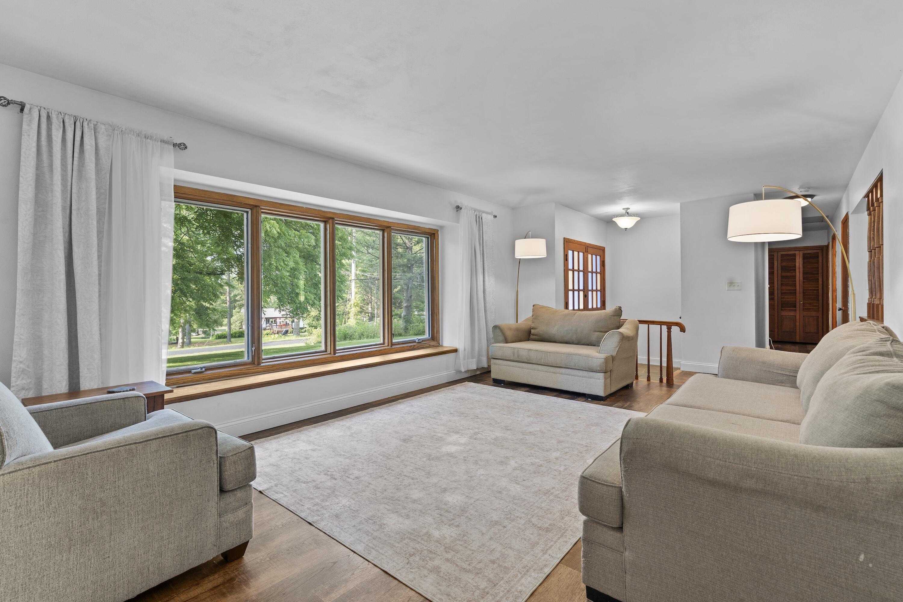 N8093 Lakeview Road Oconomowoc, WI 53066 - Photo 6 of 44 Sun drenched living room with luxury vinyl plank flooring and picture window.