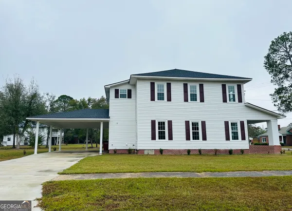 a big house with a big yard and large trees