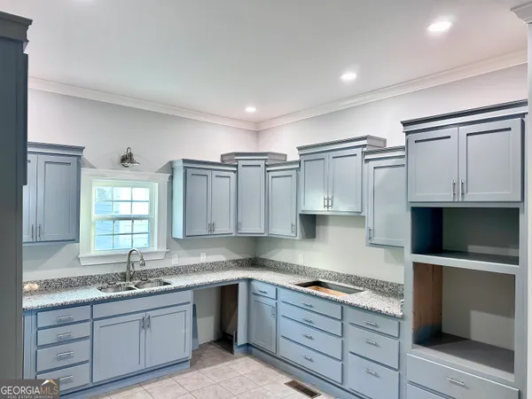 a kitchen with granite countertop a sink stainless steel appliances and cabinets