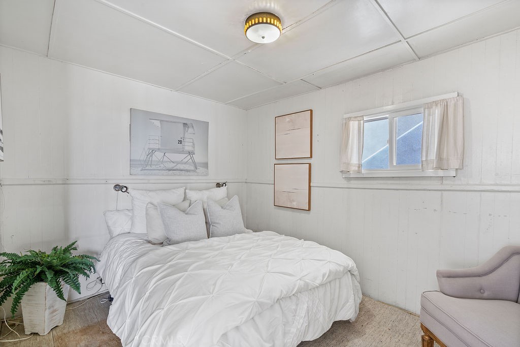 94 A Surfside Seal Beach, CA 90740 - Photo 13 of 33 a bedroom with a bed and a potted plant