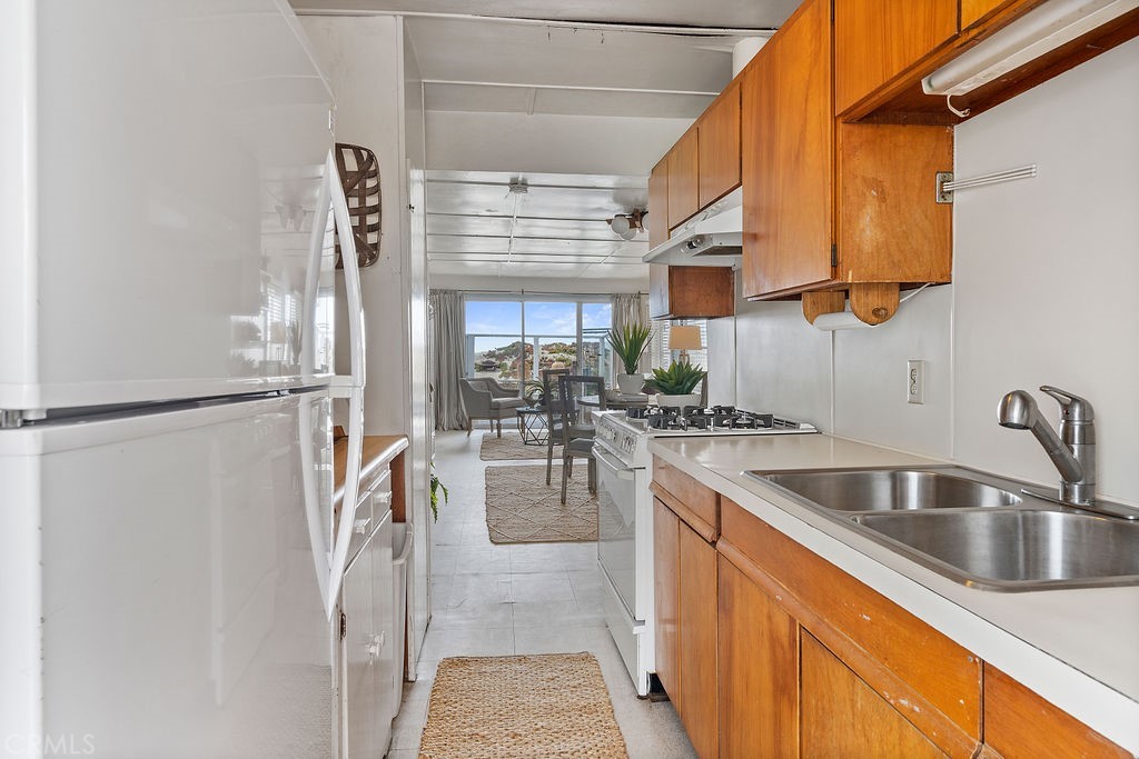 94 A Surfside Seal Beach, CA 90740 - Photo 9 of 33 a kitchen with a sink a refrigerator and cabinets