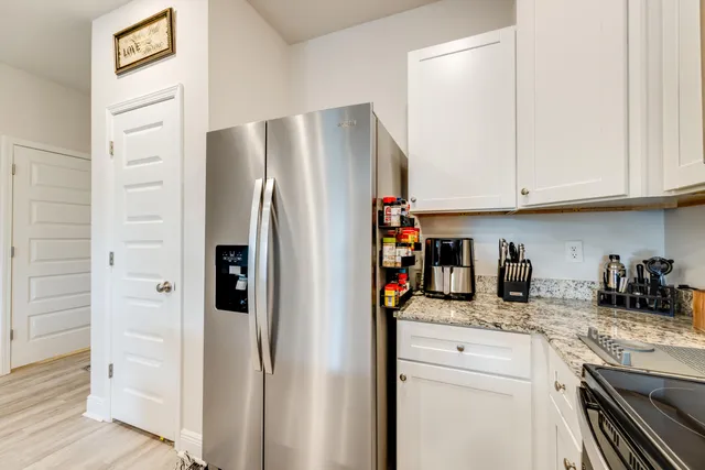a kitchen with refrigerator a microwave and cabinets
