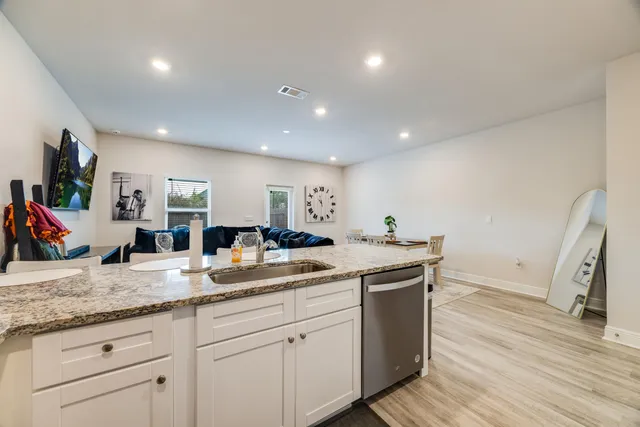 a kitchen with granite countertop a sink and a refrigerator