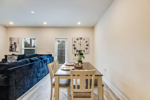a living room with furniture a chandelier and a dining table