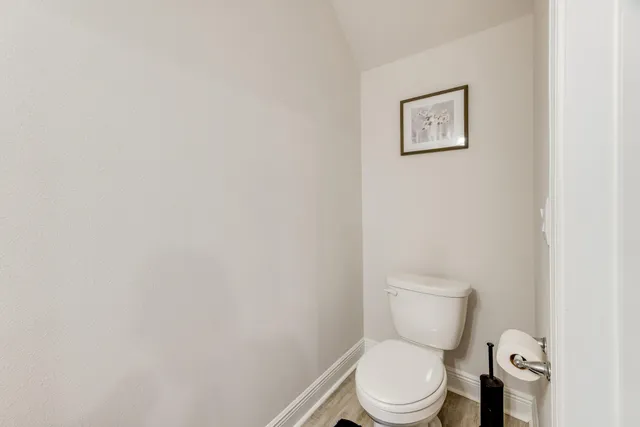 a white toilet sitting next to a white wall