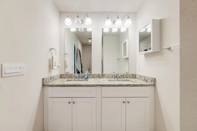 a bathroom with a granite countertop sink a large mirror and a shower