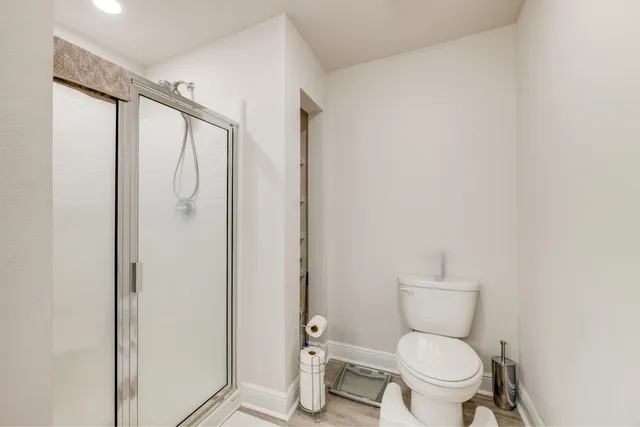 a white toilet sitting next to a shower