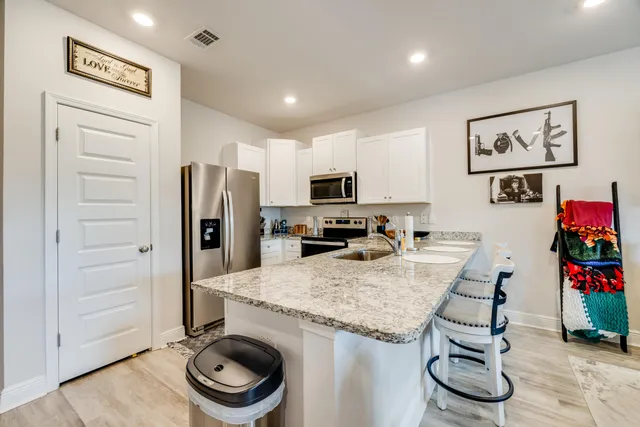 a kitchen with granite countertop a refrigerator and a sink