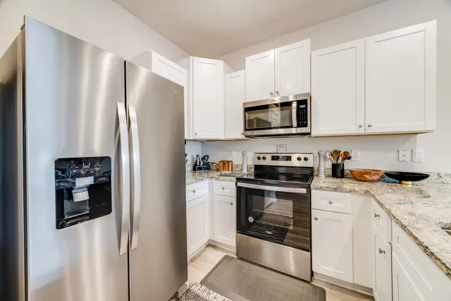 a kitchen with stainless steel appliances granite countertop a refrigerator stove and sink