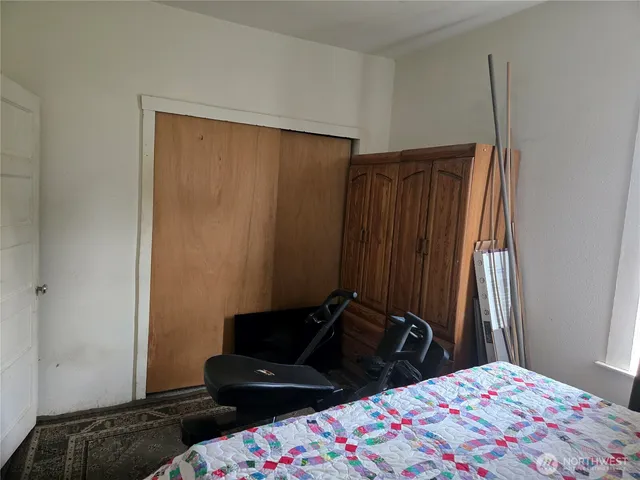 a bedroom with a bed and a mirror on dresser