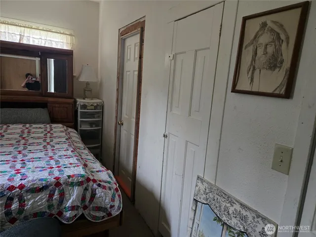 a bedroom with a bed window and mirror