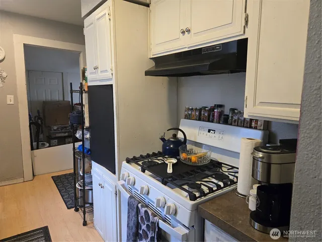 a kitchen with granite countertop lots of clutter and stainless steel appliances