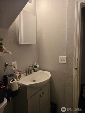 a white toilet sitting next to a sink and vanity