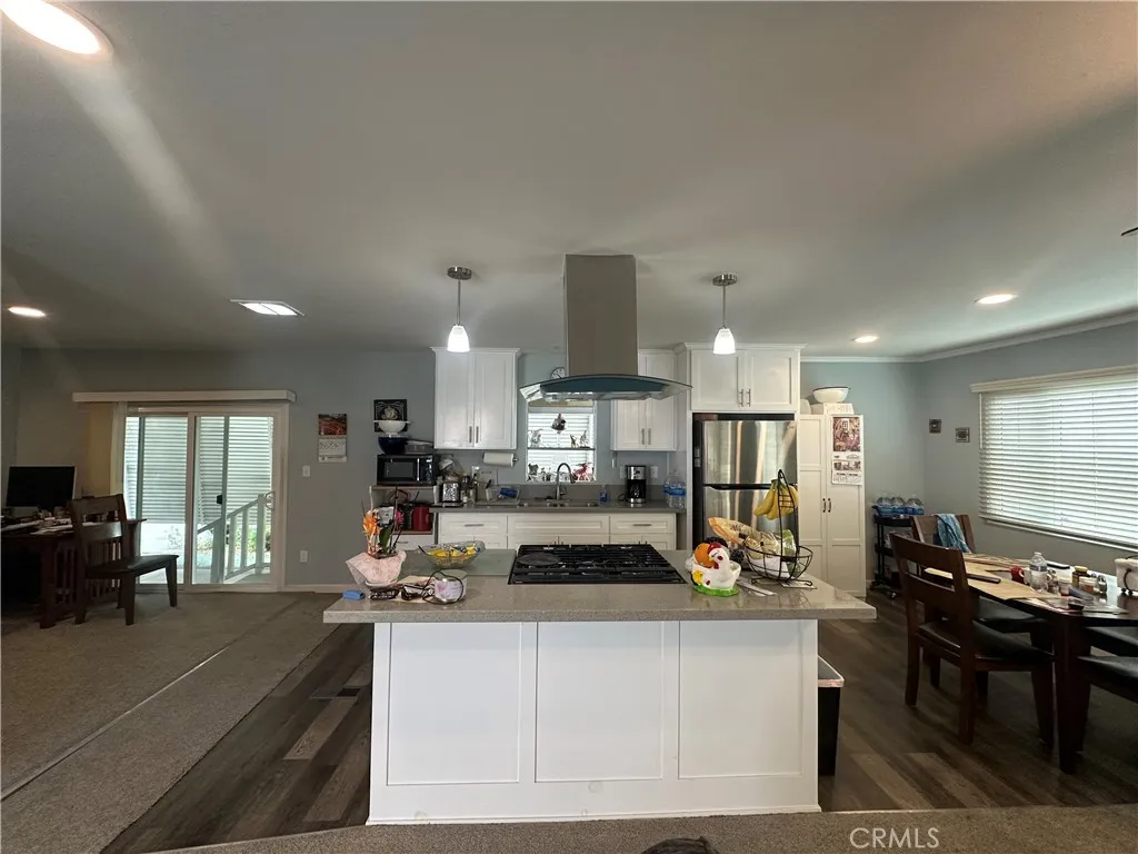 525 North Gilbert Street, Unit 151 Anaheim, CA 92801 - Photo 11 of 18 a view of a kitchen with kitchen island stainless steel appliances refrigerator stove dining table and chairs
