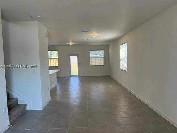 an empty room with windows and entrance