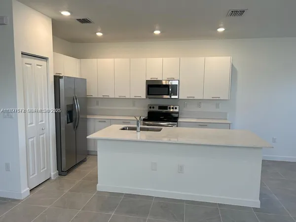 a kitchen with stainless steel appliances a refrigerator stove microwave and sink