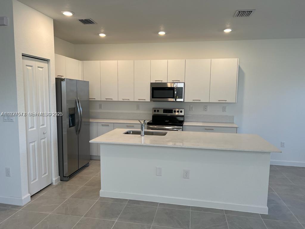 2281 Northwest 131st Circle Miami, FL 33167 - Photo 14 of 48 a kitchen with stainless steel appliances a refrigerator stove microwave and sink