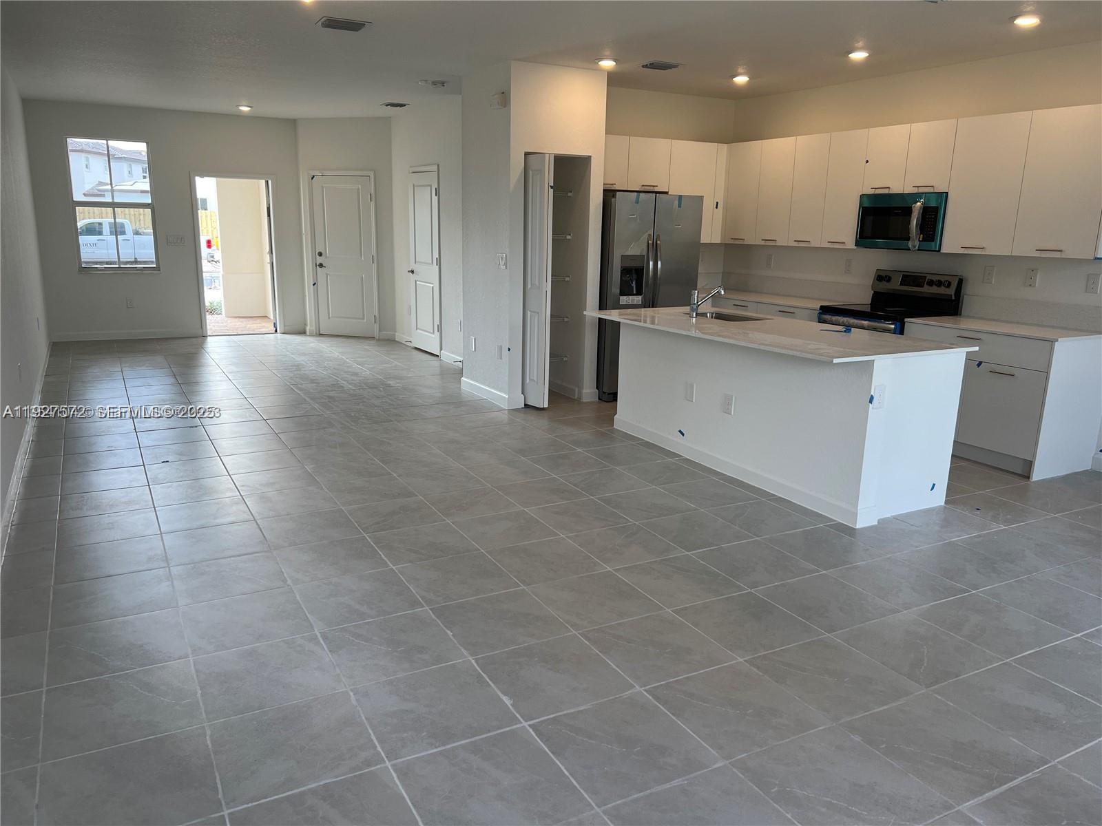 2281 Northwest 131st Circle Miami, FL 33167 - Photo 15 of 48 a view of kitchen with kitchen island stainless steel appliances a sink a counter top space cabinets and a view of living room