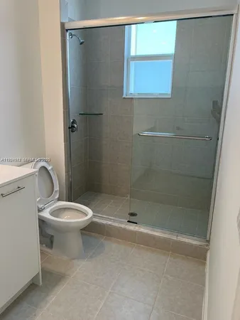 a white toilet sitting next to a shower