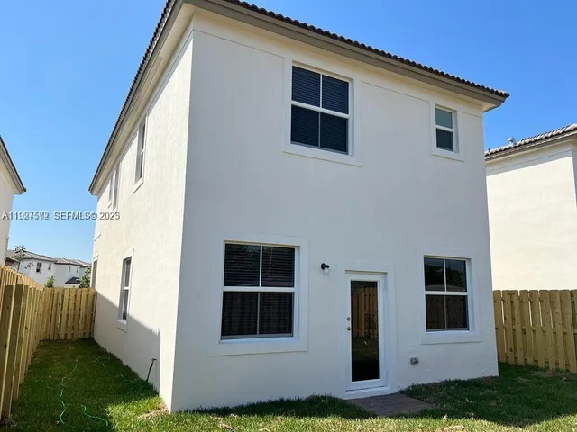 a view of white house with a yard