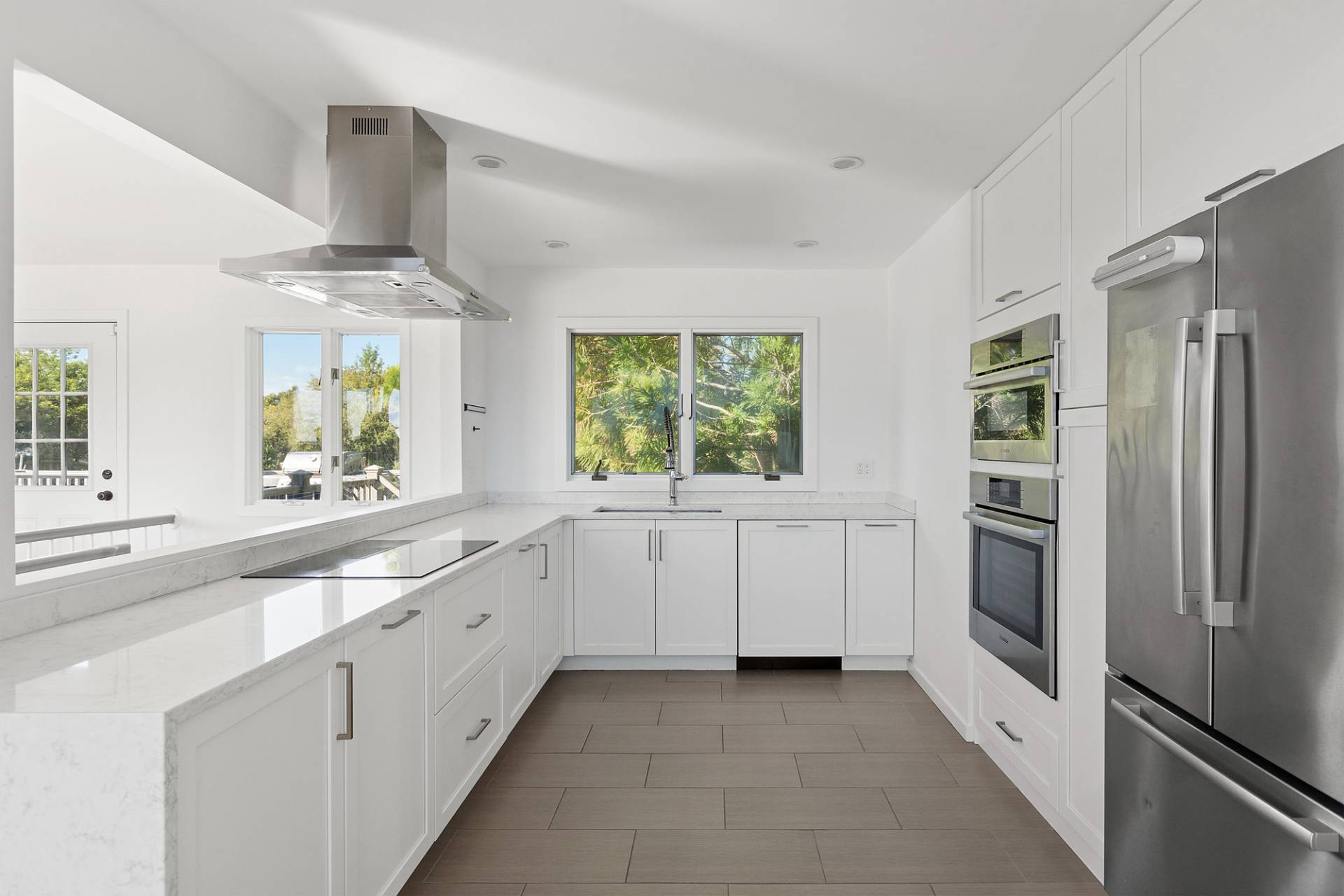 4 Bayberry Lane Remsenburg, NY 11960 - Photo 5 of 29 a large white kitchen with stainless steel appliances and a window