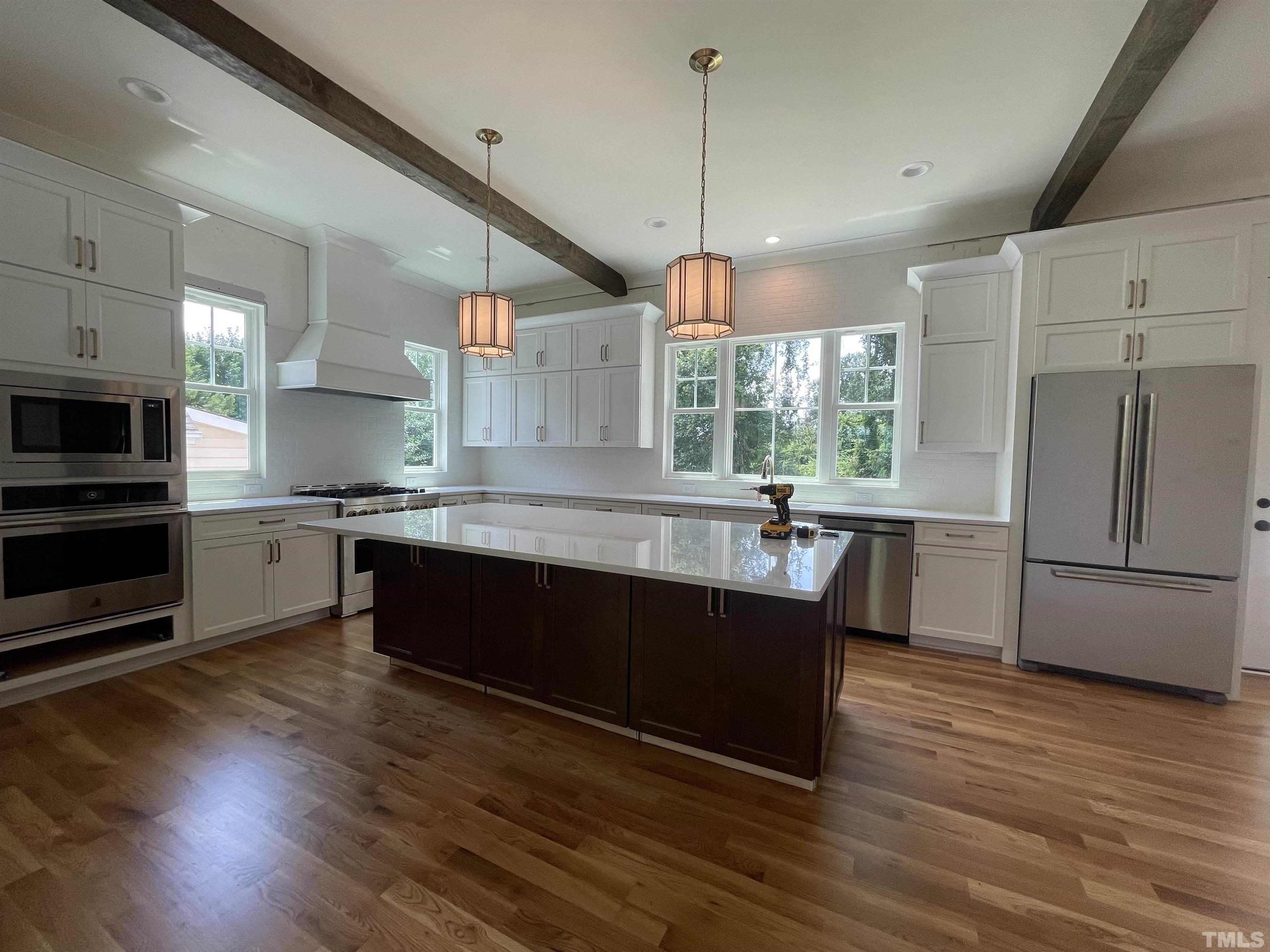 400 Pershing Road Raleigh, NC 27608 - Photo 11 of 33 a large kitchen with stainless steel appliances granite countertop a sink a stove and a wooden floors