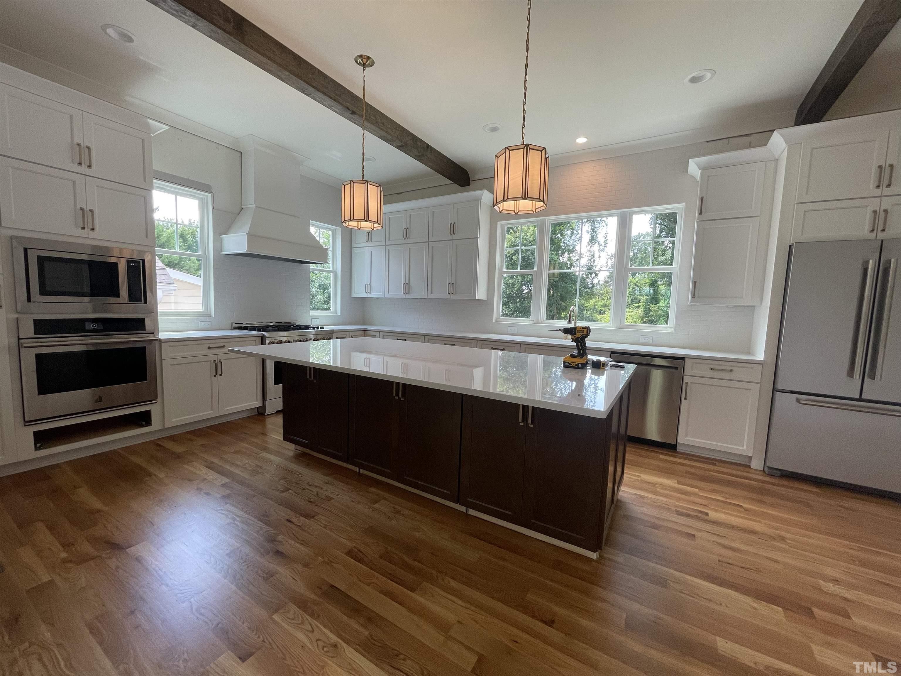 400 Pershing Road Raleigh, NC 27608 - Photo 12 of 33 a kitchen with wooden floors and stainless steel appliances
