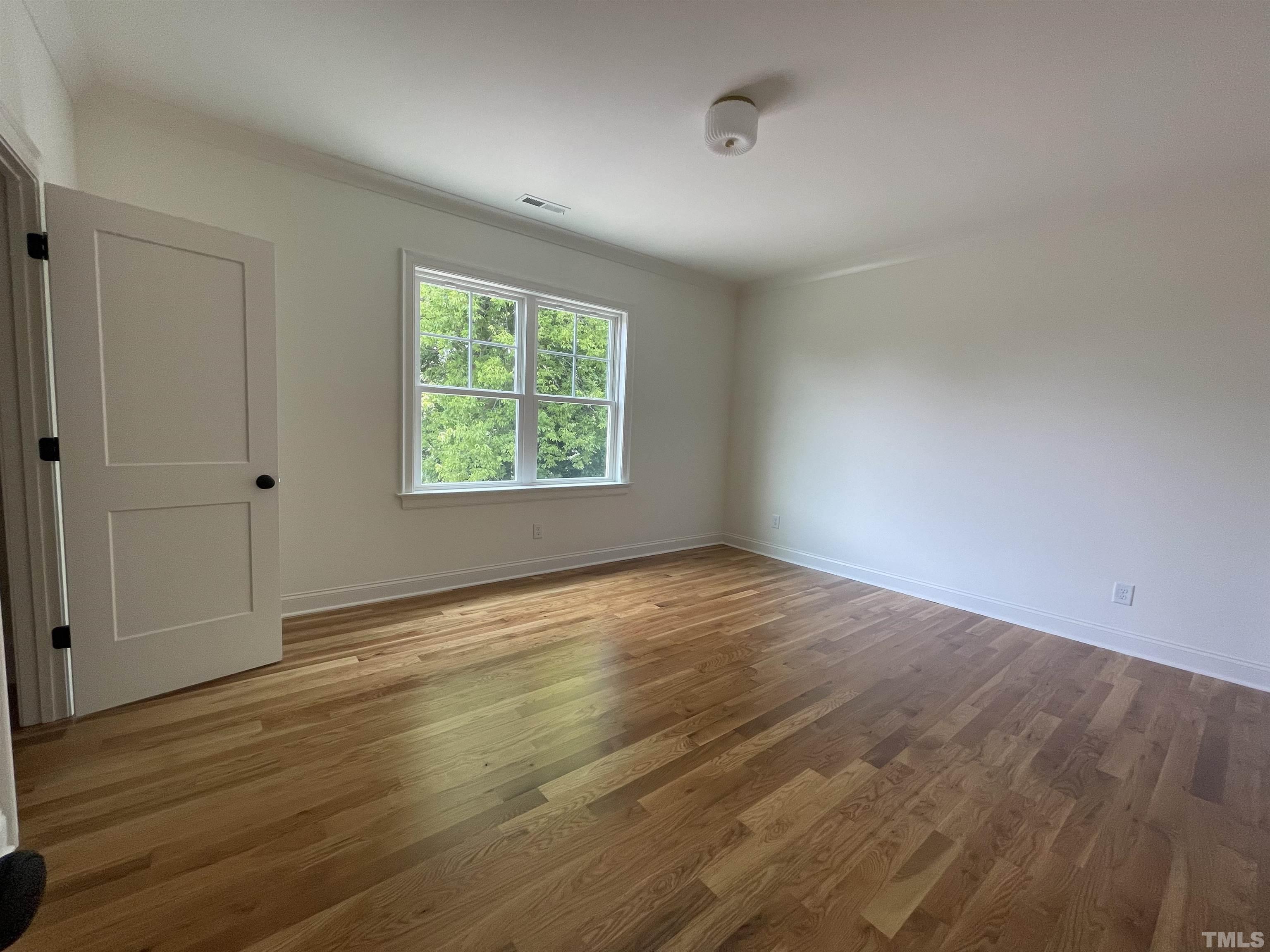 400 Pershing Road Raleigh, NC 27608 - Photo 25 of 33 an empty room with wooden floor and windows