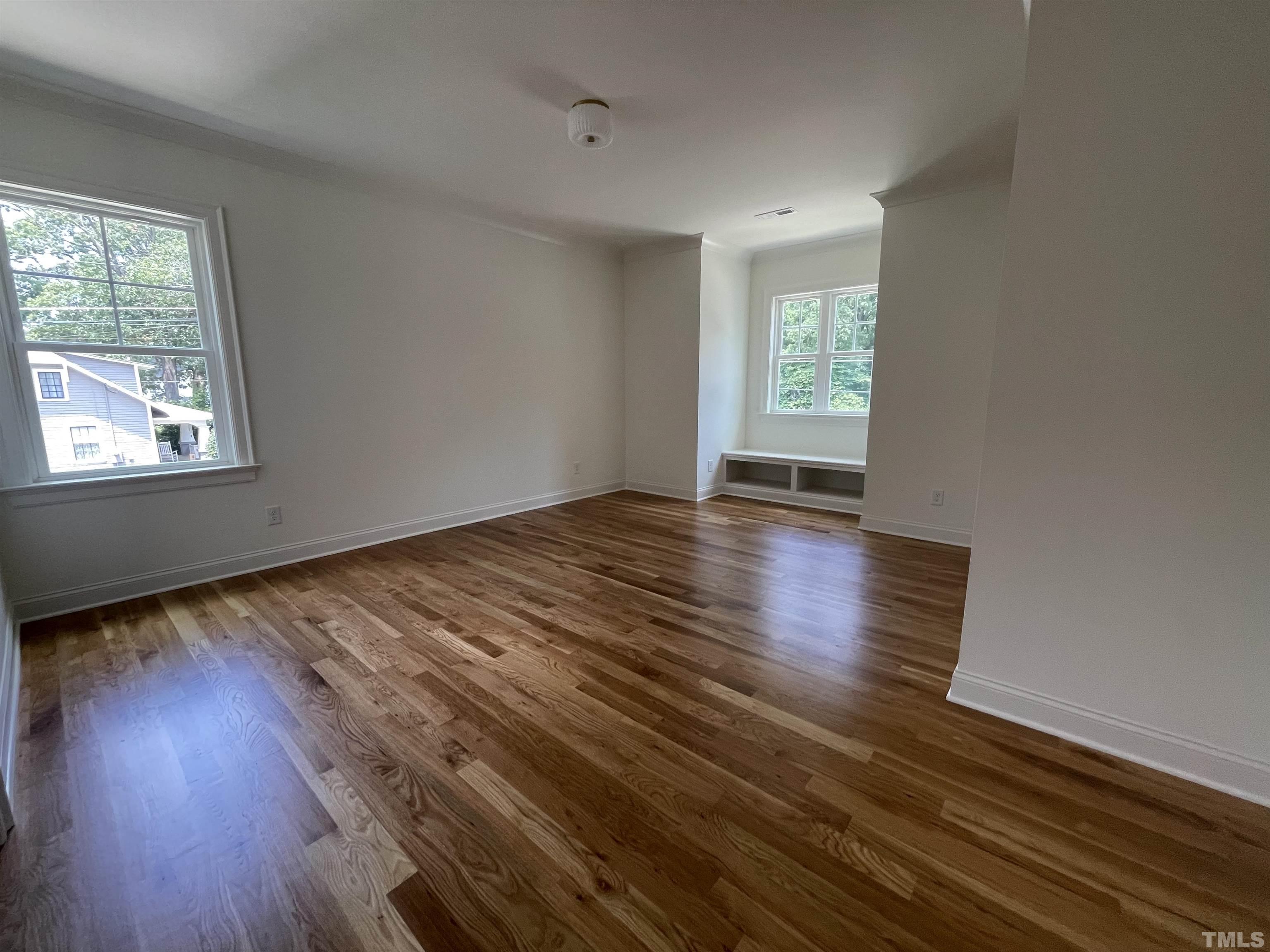 400 Pershing Road Raleigh, NC 27608 - Photo 26 of 33 an empty room with wooden floor and windows