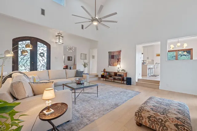 a living room with furniture a large window and a chandelier