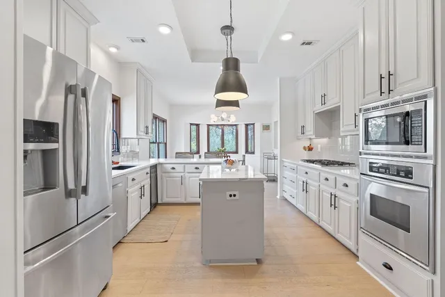 a kitchen with white cabinets and stainless steel appliances