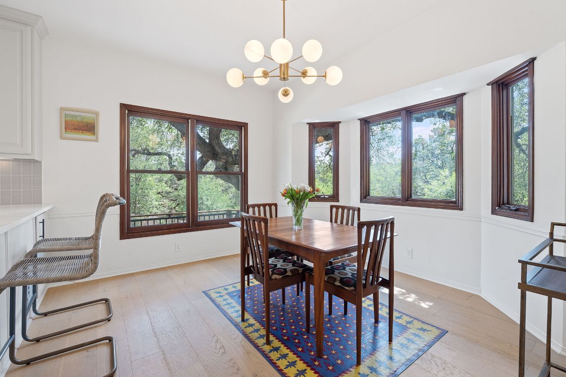 6302 Gato Path Austin, TX 78731 - Photo 14 of 37 Dining space featuring plenty of natural light, light wood finished floors, and a chandelier