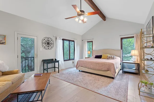 a bedroom with a bed a chandelier and dresser