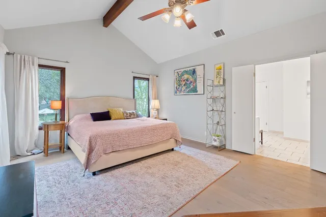 a bedroom with a large bed and a chandelier