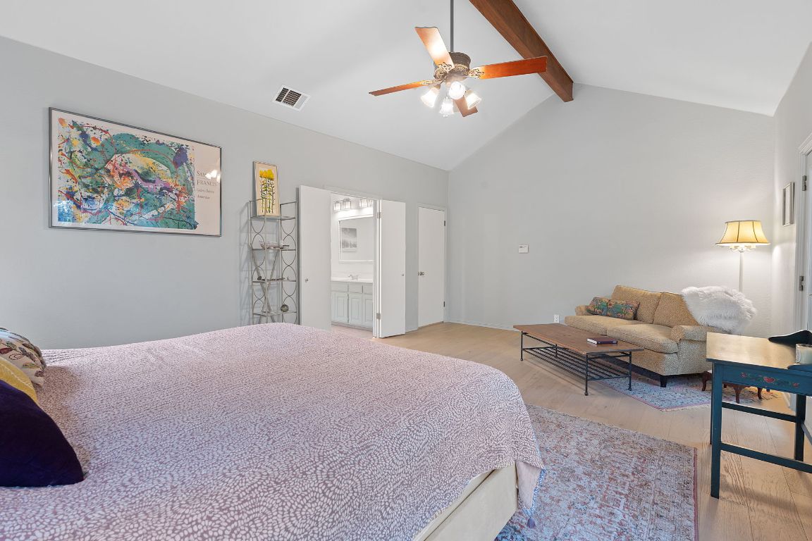 6302 Gato Path Austin, TX 78731 - Photo 17 of 37 Bedroom with light wood-style flooring, beamed ceiling, ensuite bath, ceiling fan, and high vaulted ceiling