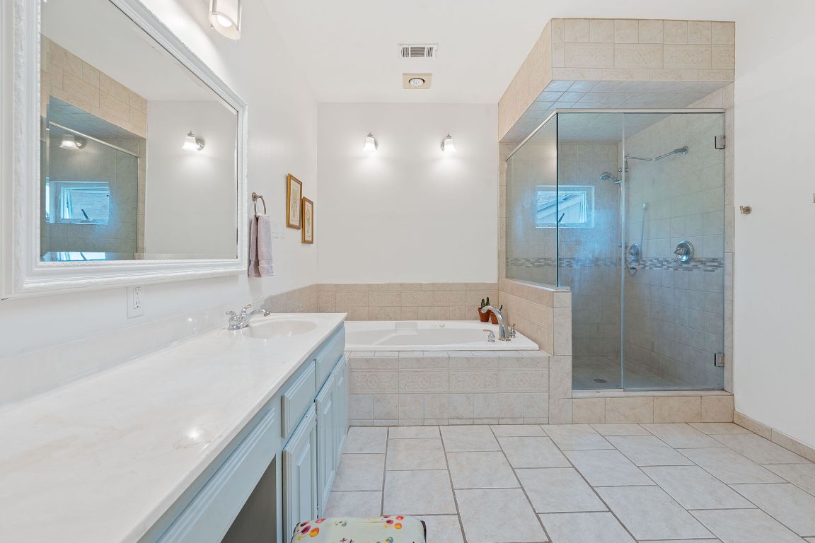 6302 Gato Path Austin, TX 78731 - Photo 19 of 37 Bathroom with a garden tub, vanity, tile patterned flooring, and a shower stall