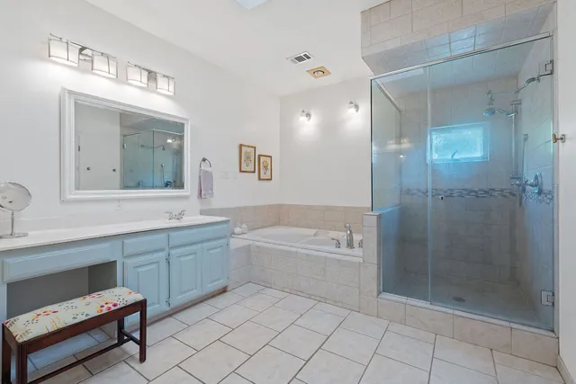 a bathroom with a bathtub shower sink and mirror
