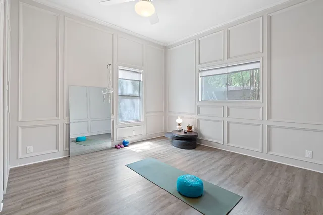an empty room with wooden floor and windows
