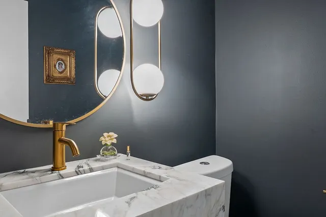 a bathroom with a sink mirror vanity and toilet