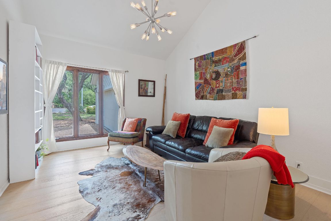 6302 Gato Path Austin, TX 78731 - Photo 5 of 37 Living room with a chandelier, wood finished floors, and high vaulted ceiling