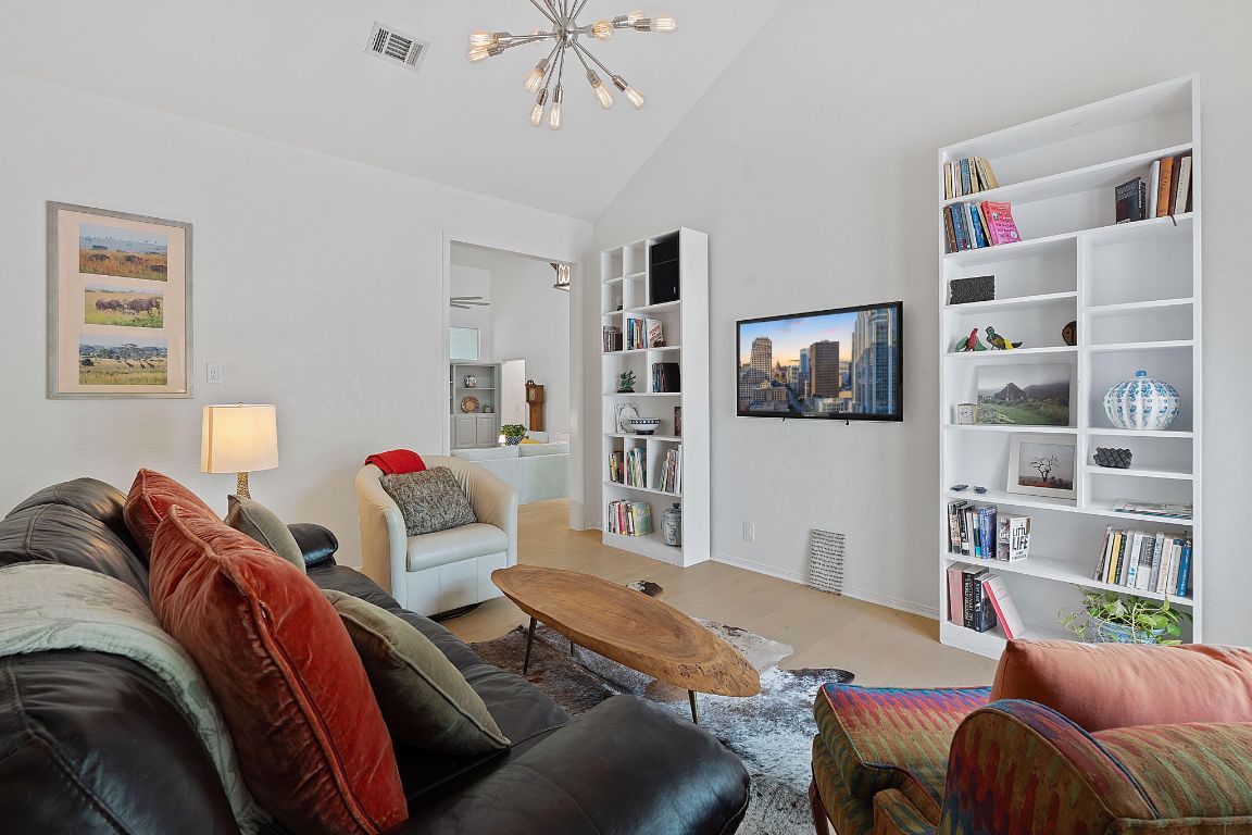 6302 Gato Path Austin, TX 78731 - Photo 6 of 37 Living room with a chandelier, light wood-style floors, and vaulted ceiling