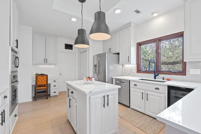 a kitchen that has a lot of cabinets in it and wooden floors