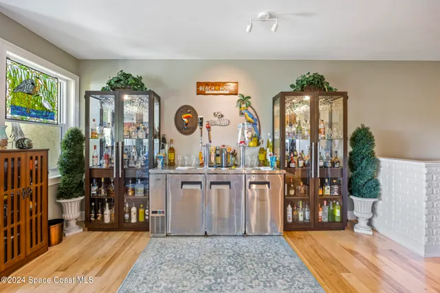 a large room with lots of wooden furniture a rug and a large window