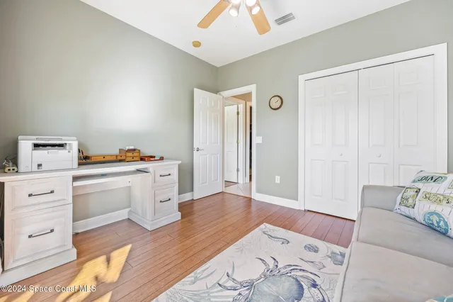 a bedroom with a bed wooden floor and a lamp on table