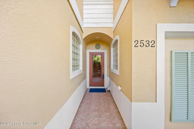 a view of a hallway with entryway wooden floor and front door