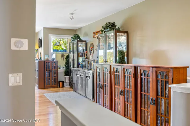 a view of a hallway with wooden floor and windows