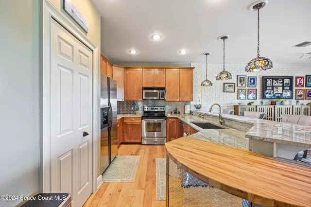 a kitchen with stainless steel appliances kitchen island granite countertop a stove and white cabinets