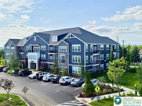 a front view of a building with cars parked